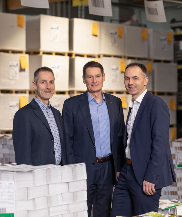 Gruppenbild Stefan und Christian Aumüller und Volker Dollinger, im Hintergrund Papierlager