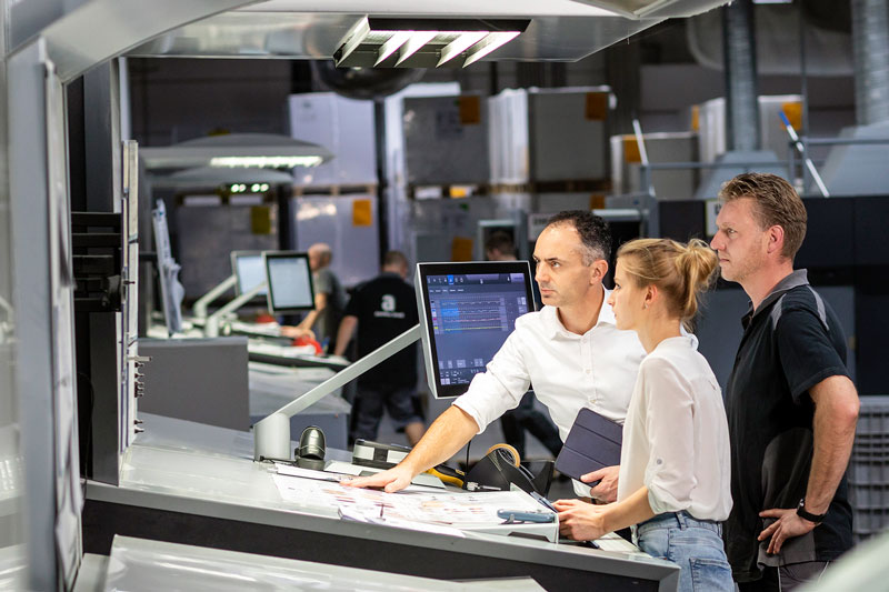 a group of people standing in front of a computer