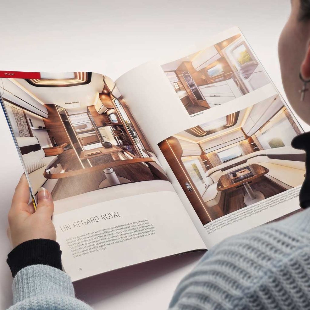 Caravan Salon Düsseldorf 3 Person die ein Magazin über Capmer ließt