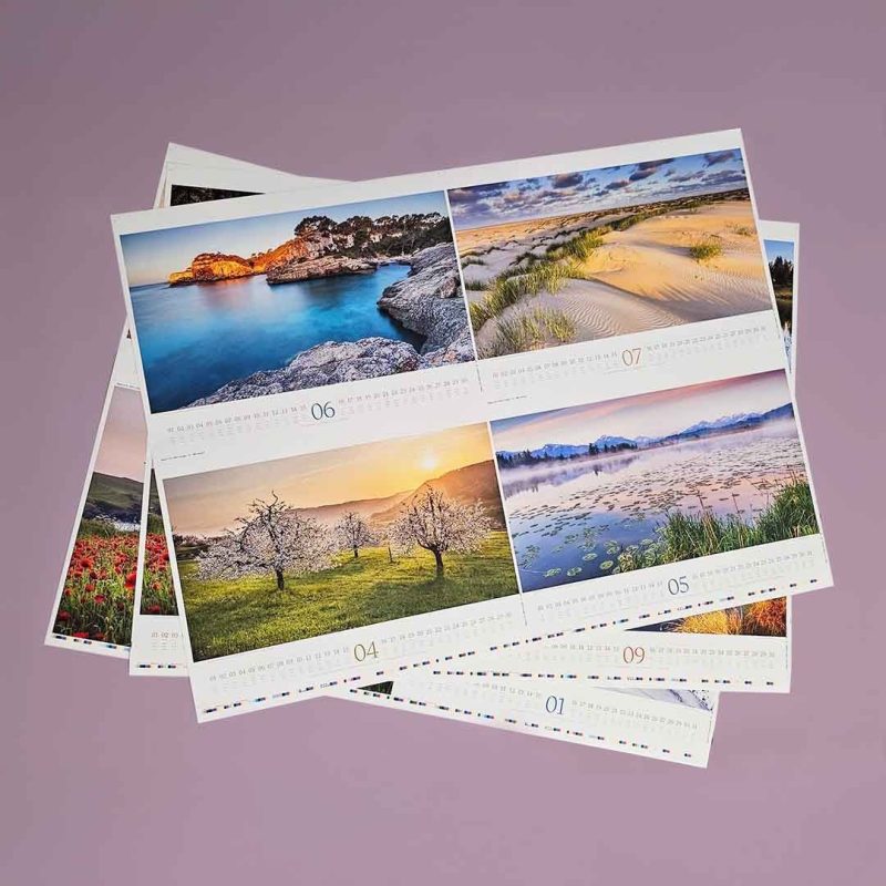 Aufgefächerte Kalender Bögen auf denen Landschaften abgebildet sind